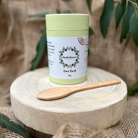 A container of Emu Bush leaves (Eremophila Alternifolia) with a wooden spoon, presented on a naturalistic background.