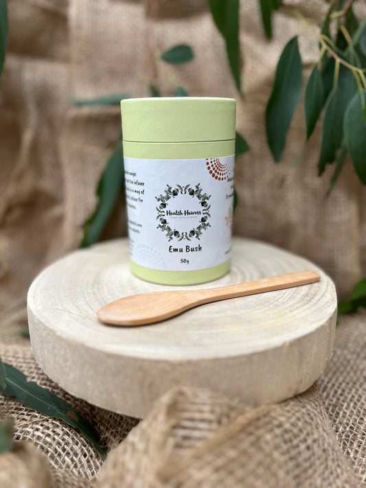 A container of Emu Bush leaves (Eremophila Alternifolia) with a wooden spoon, presented on a naturalistic background.